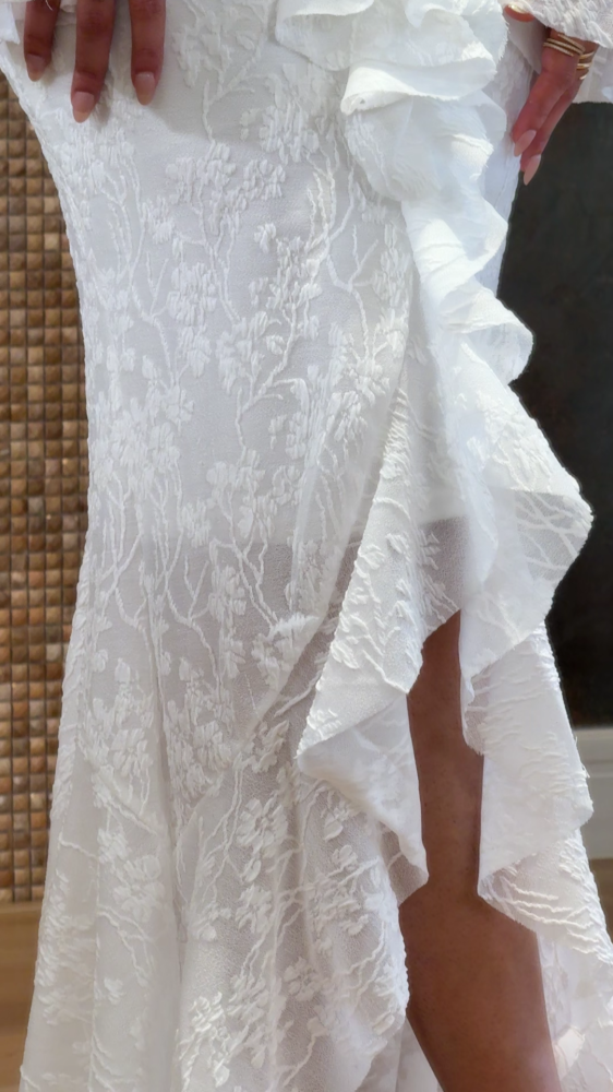 White lace dress decorated with ruffles
