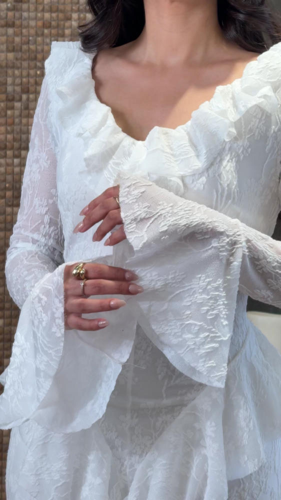 White lace dress decorated with ruffles